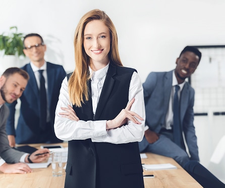 Businesswoman standing confidently with colleagues in office
