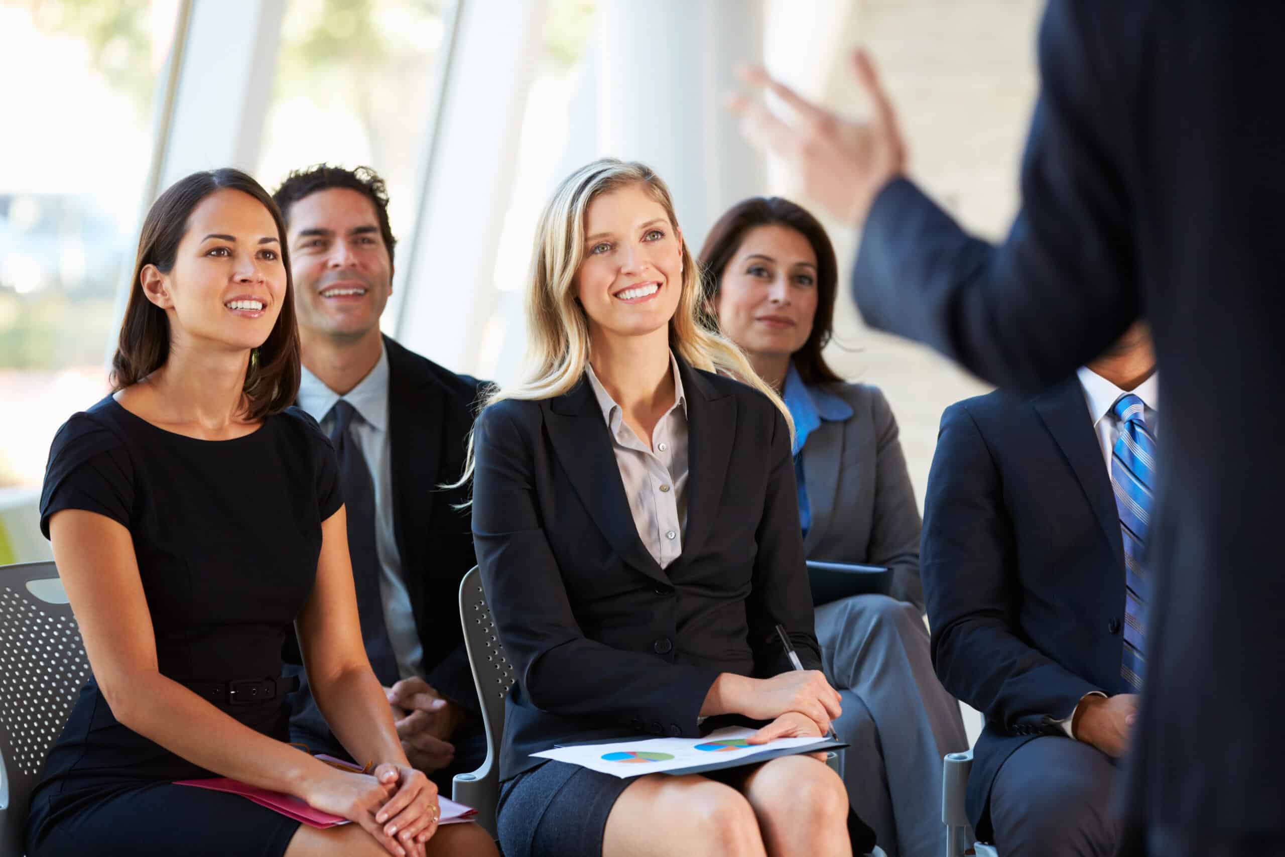 Business professionals seated and listening during a presentation